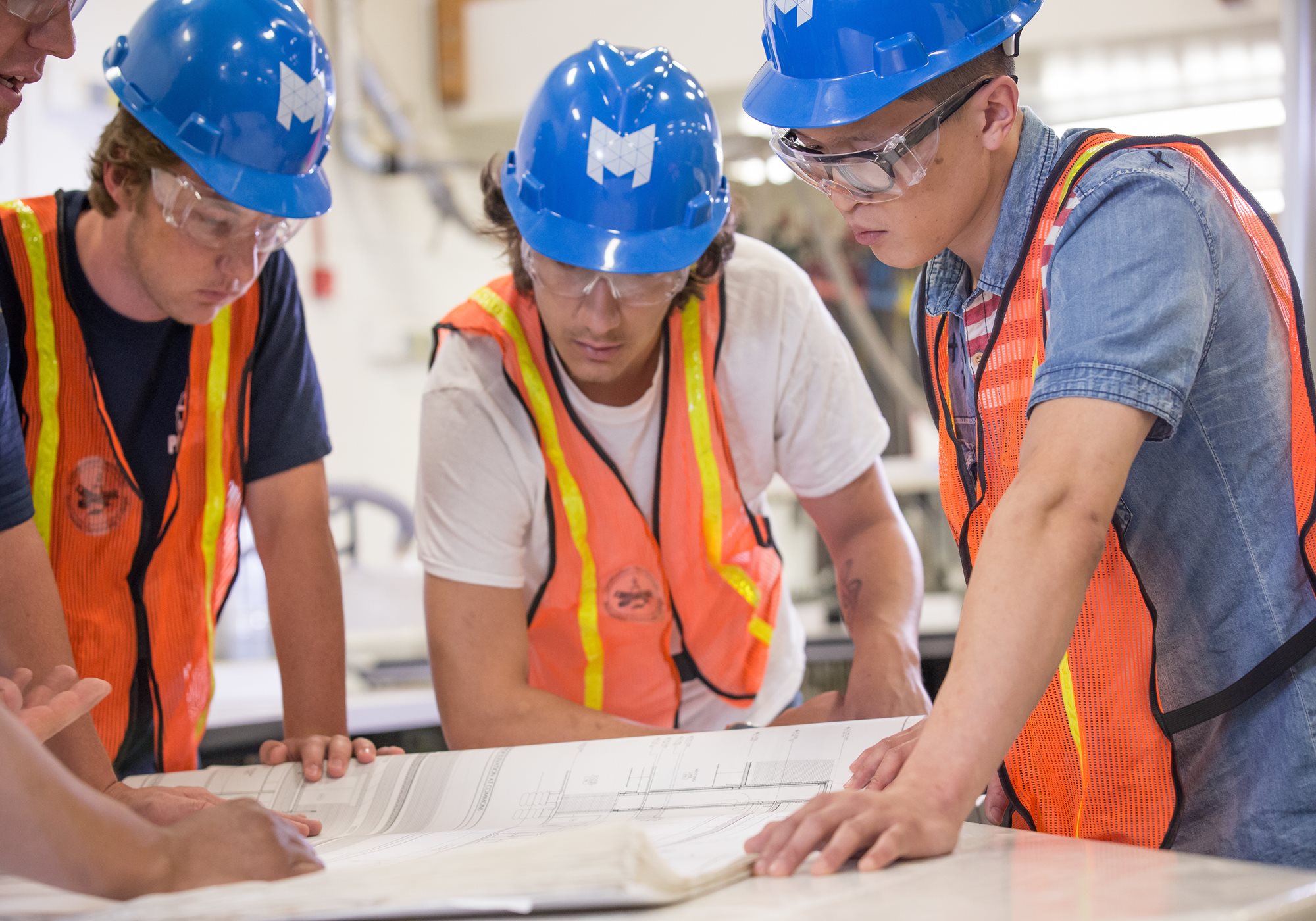 Group of students looking at blue print