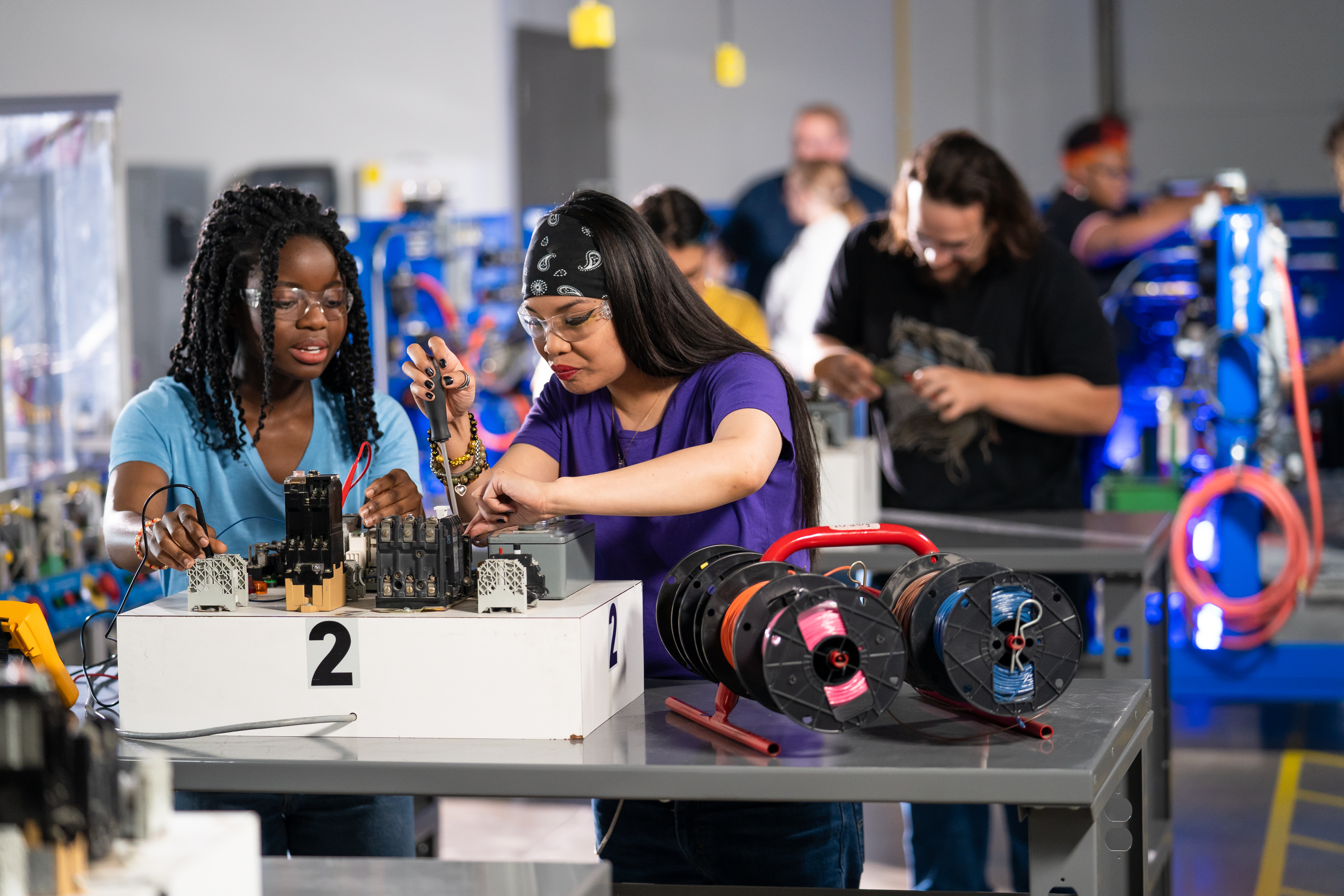 Two woman working on a manufacturing project in a classroom setting. 