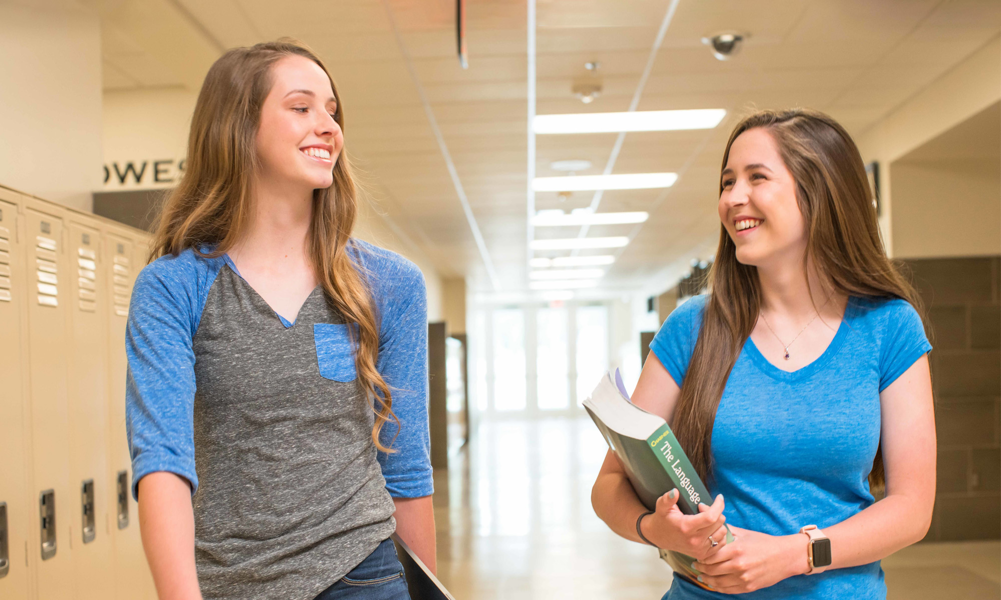 Two female students walking down the school hallways