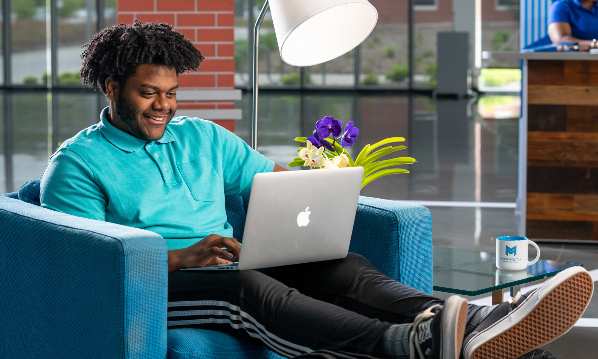 Happy male student working on laptop